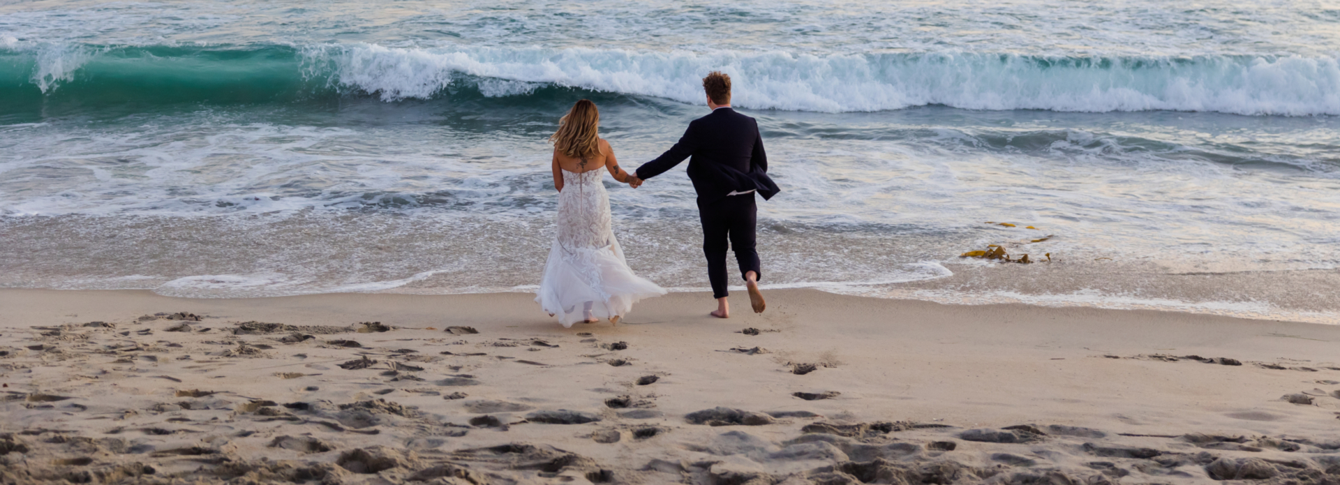 Couple at the beach on their wedding day captured by Carlsbad Photo at Tamarack Beach in Carlsbad